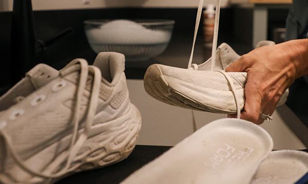 Shoelaces being removed from a pair of running shoes