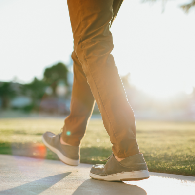 Man walking on sidewalk at sunset