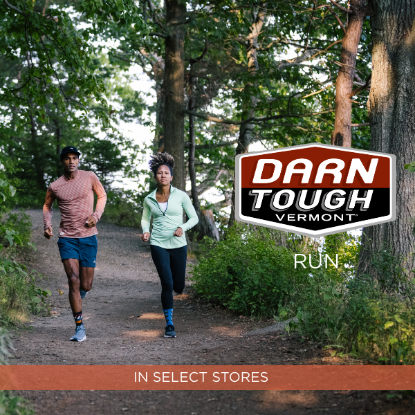 Man and woman running through trail in woods