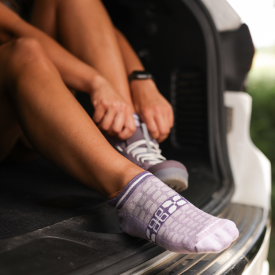 Man putting on socks in back of car