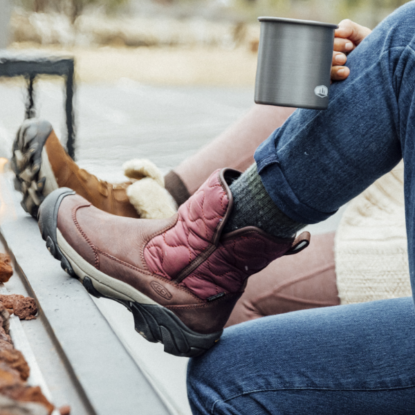 Woman resting foot on ledge of outdoor fireplace