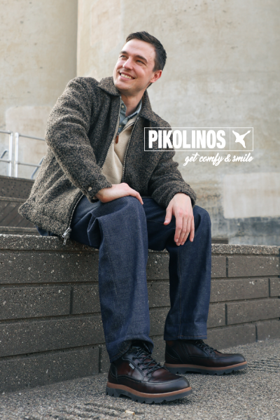 Man sitting on ledge in Minneapolis wearing Pikolinos boots