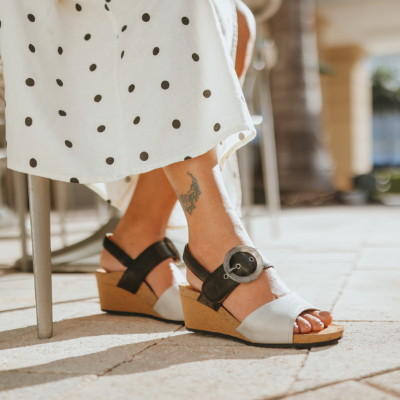 Woman resting feet on sidewalk
