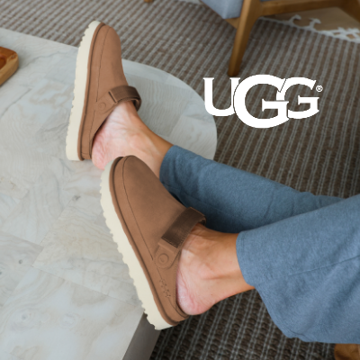 Woman resting feet on ottoman wearing UGG® Goldenstar Clog Slipper