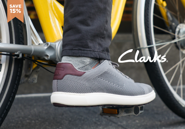 Man resting foot on bike pedal wearing Clarks