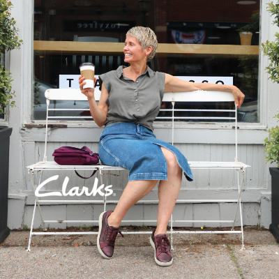 Woman sitting on bench outside of coffee shop