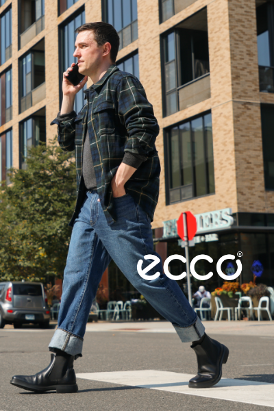 Man talking on phone while crossing a crosswalk in Ecco boots