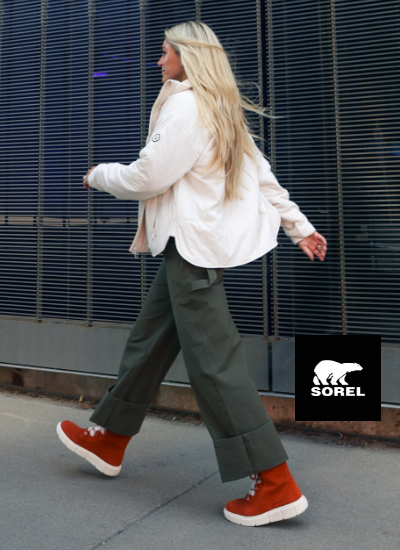 Woman walking on sidewalk in Sorel boots