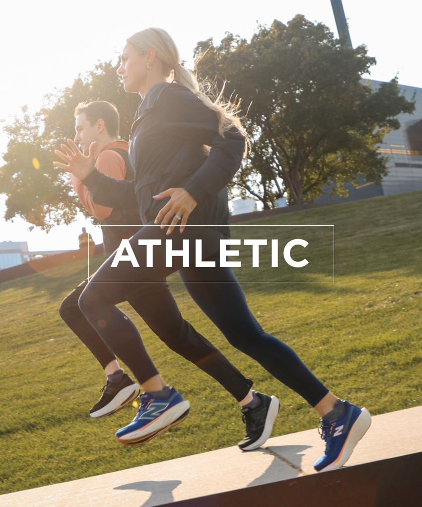 Man and woman running downtown wearing New Balance running shoes