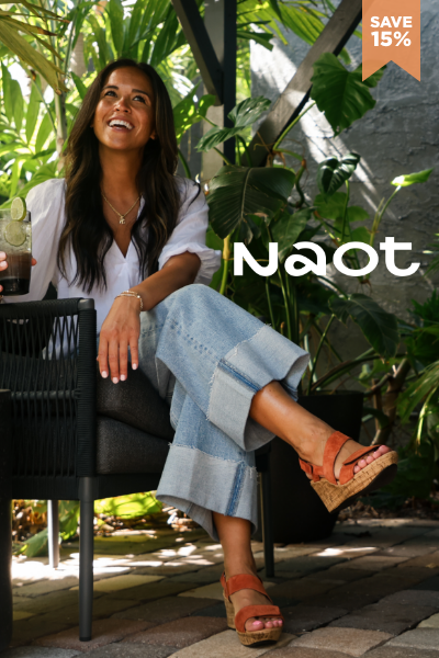 Woman sitting in chair wearing Naot sandals