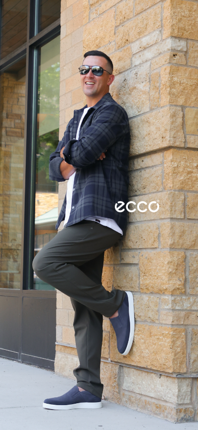 Man leaning against side of building