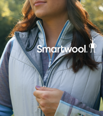 Woman zipping up Smartwool vest