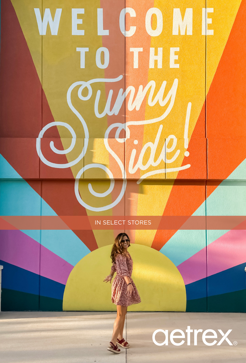 Woman twirling in front of mural