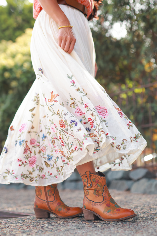 Woman twirling dress on sidewalk