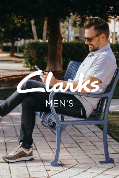 Man sitting on bench outside looking at phone
