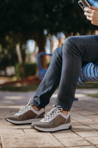 Man resting feet on sidewalk