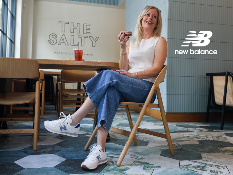 Woman eating a donut at The Salty in West Palm Beach wearing New Balance 574 lifestyle sneakers 