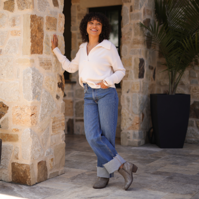 Woman standing by pillar smiling
