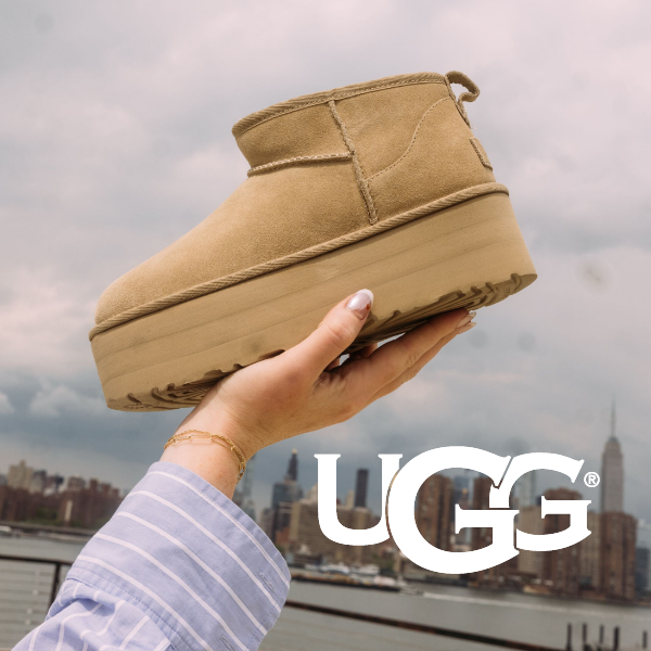 Woman holding UGG up to sky