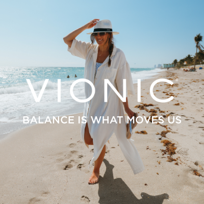 Woman walking on beach holding shoes