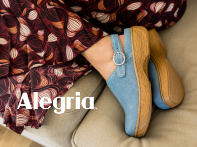 Woman with feet curled up on couch wearing Alegria Olie