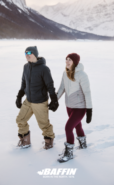 Man and woman walking through snow on frozen lake wearing Baffin winter boots