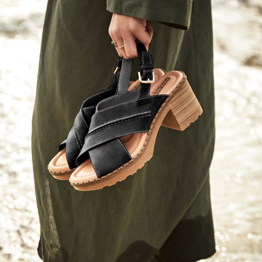 Woman holding shoes in hand