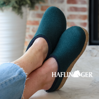 Woman crossing feet on ottoman wearing Haflinger slippers