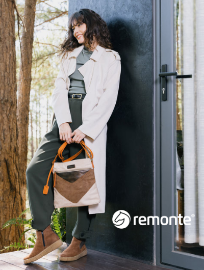 Woman leaning against building wearing Remonte boots