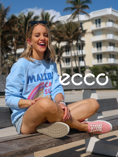 Woman sitting on park bench wearing Ecco Soft 7 Sneakers