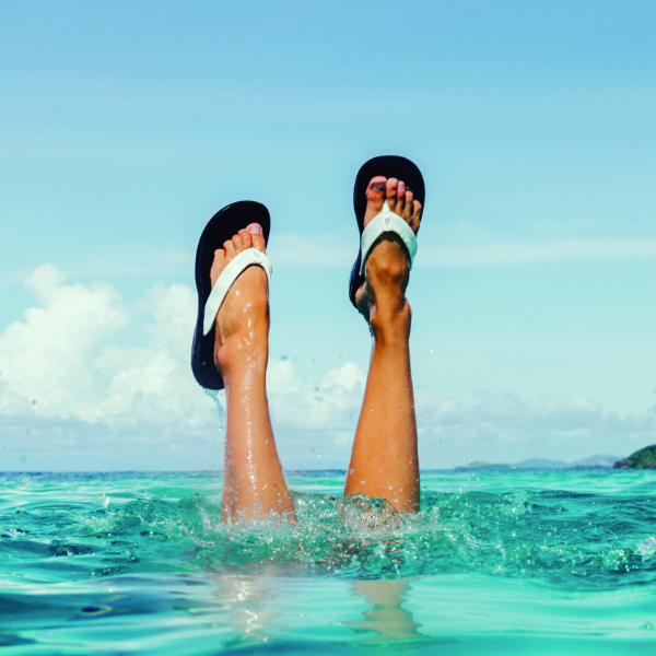 Woman holding feet above water