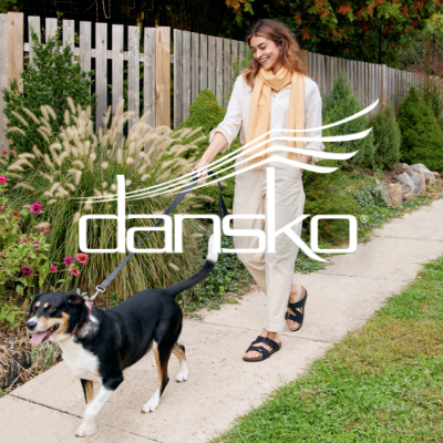 Woman walking dog on sidewalk