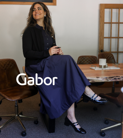Woman sitting on office table crossing legs in Gabor Tara 730 mary janes
