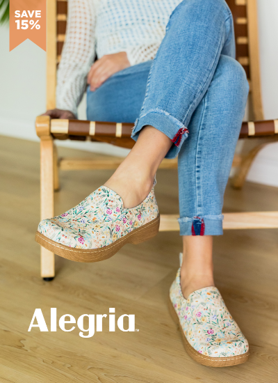 Woman sitting in chair wearing Alegria clogs
