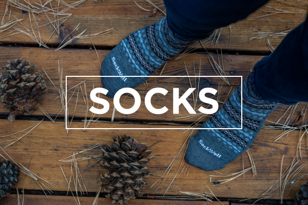 Person standing on deck covered in pine needles wearing Sockwell