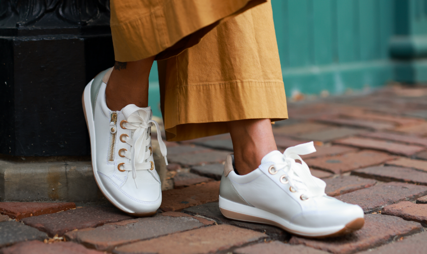 Woman leaning foot against building