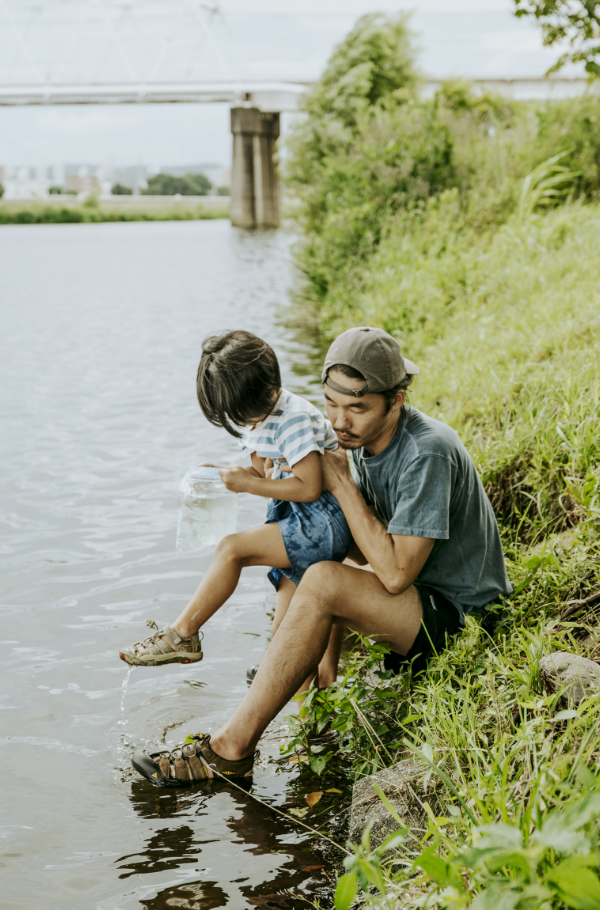Dad and kid playing by the water