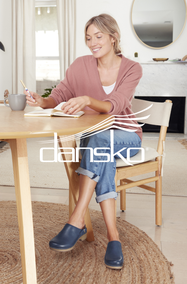 Woman sitting at table writing on notepad