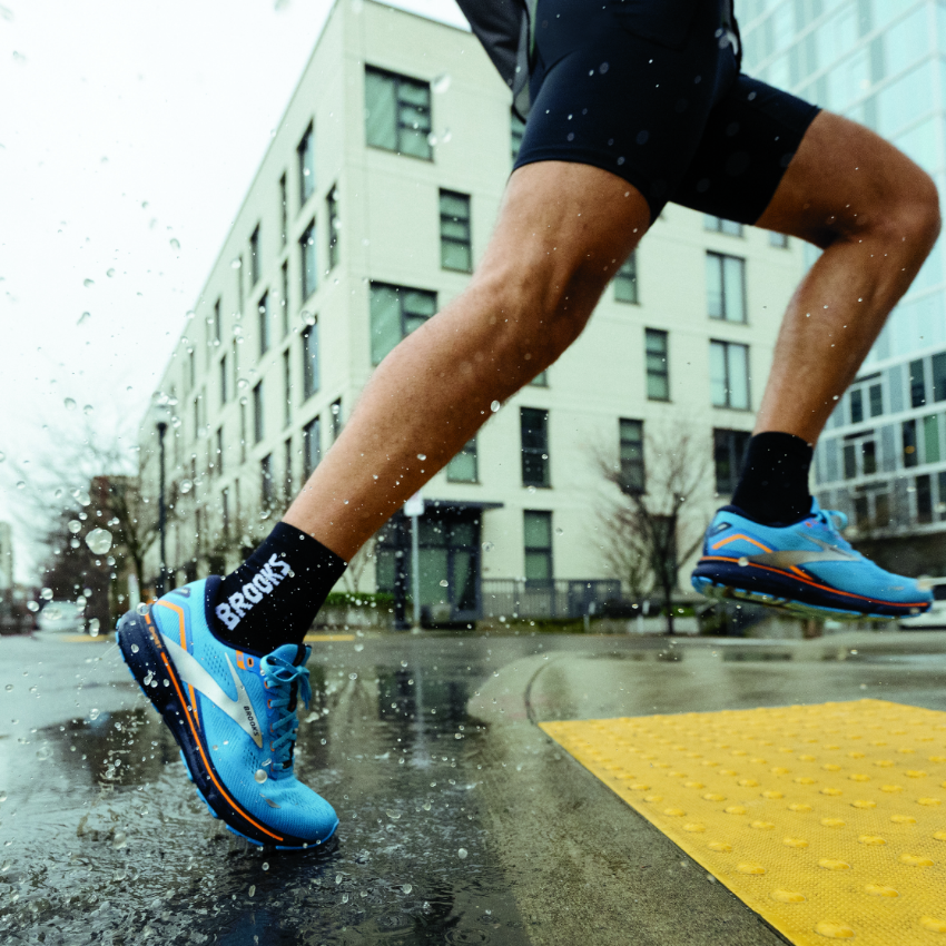 Man running across crosswalk in rain