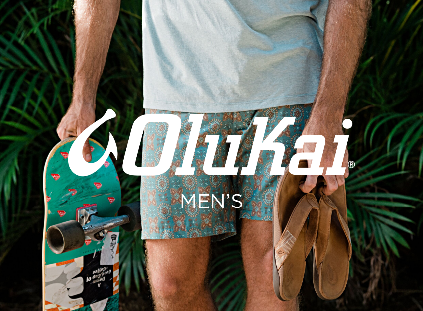 Man holding sandals and skateboard in hand