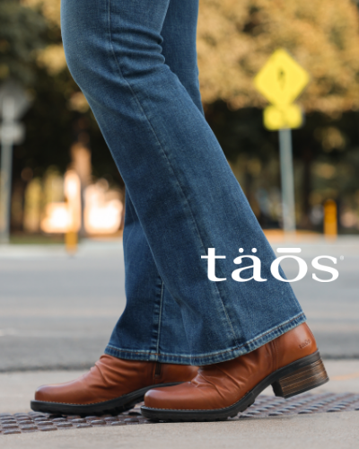 Woman standing at crosswalk wearing Taos boots