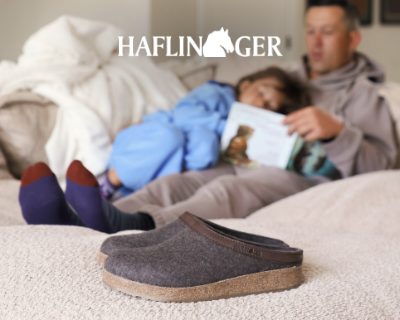 Dad reading daughter a book with Haflinger Grizzly Leather slippers on the floors