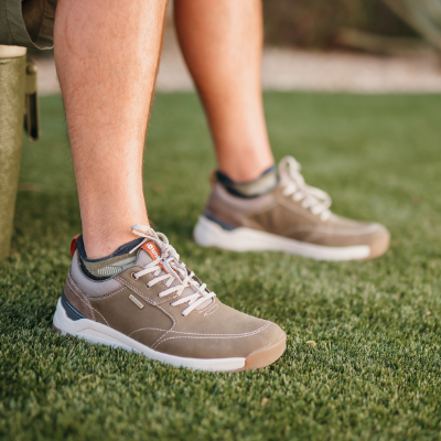 Man sitting on cooler with feet in grass