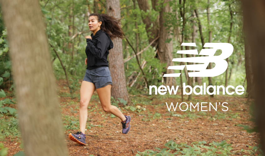 Woman running through forest on path