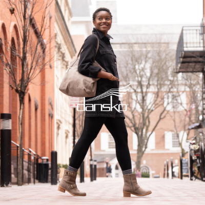 Woman walking in downtown area with Dansko Delphine boots