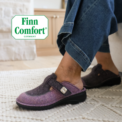 Woman sitting on couch wearing Finn Comfort Antholz slippers