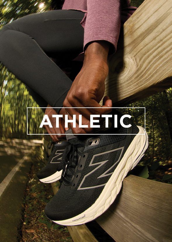 Woman sitting on fence adjusting her athletic shoes