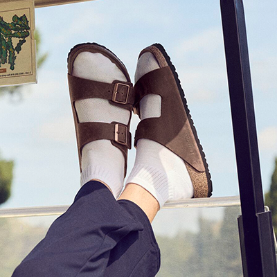Birkenstock Arizona Man wearing Birkenstock Arizona sandals sitting in a golf cart