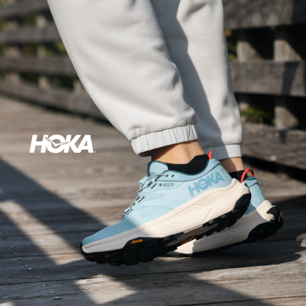 Woman walking on bridge in Hoka Transports