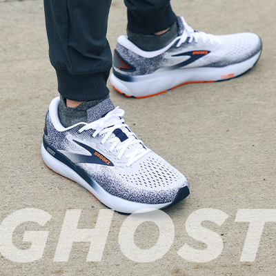 Man standing on pavement wearing Brooks Ghost 16 running shoes